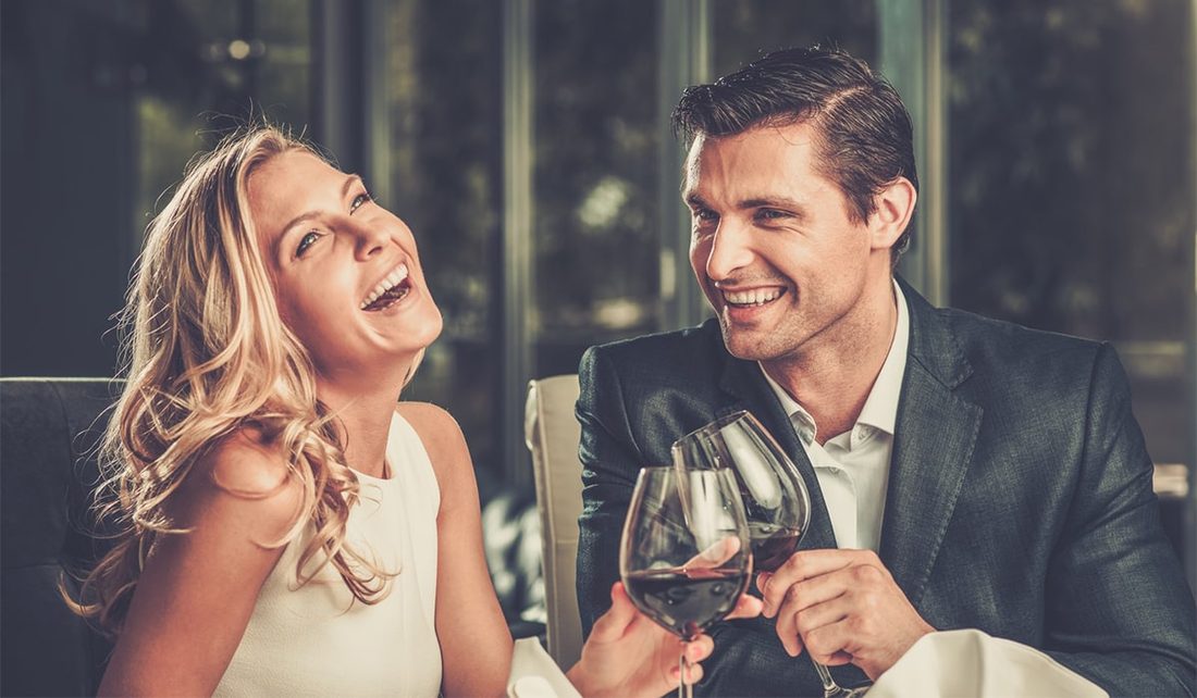 Couple laughing over wine on a date