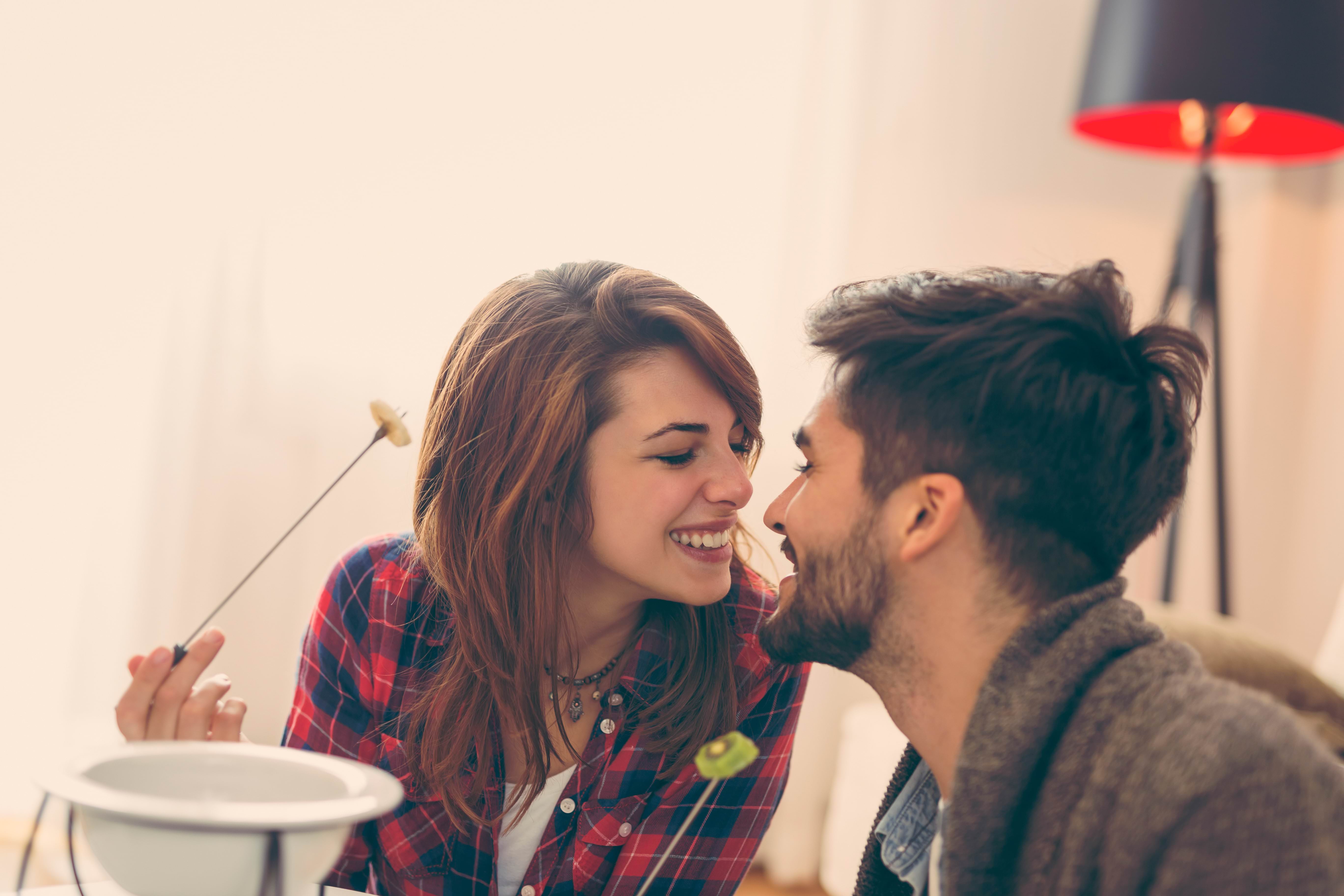 Couple laughing over a fondue dinner date, the playful in-person chemistry that good texting builds