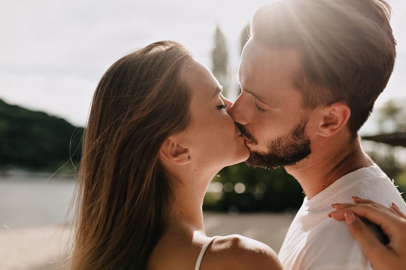 Couple kissing at the end of a great first date, the payoff of building a ladder of yeses